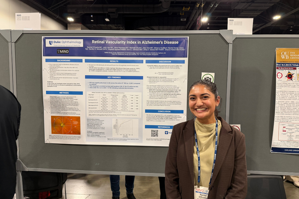 Duke trainee in front of ARVO poster