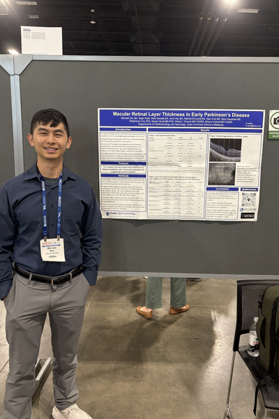 Duke trainee in front of ARVO poster