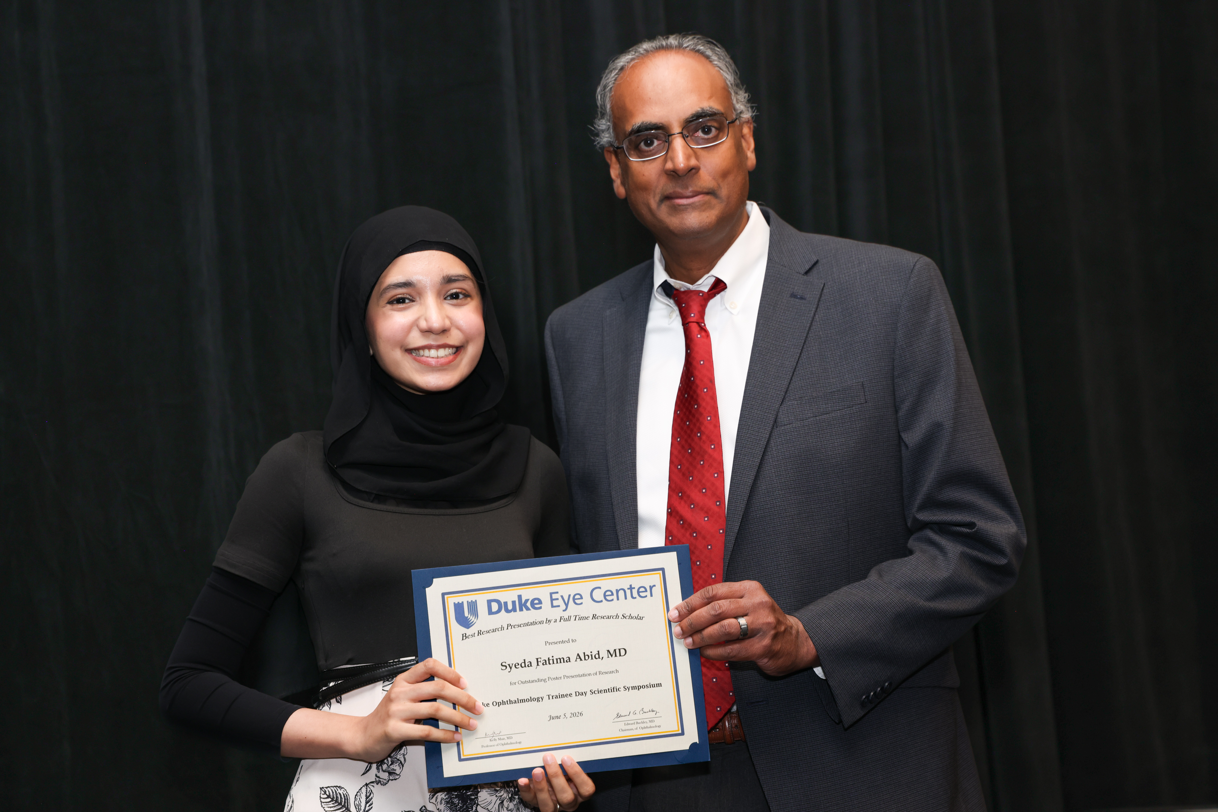 Challa with research fellow presenting plaque for award