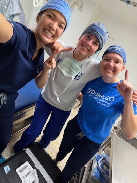 Three members of duke team posing for photo in scrub hats