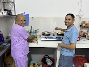 two people standing cooking a meal